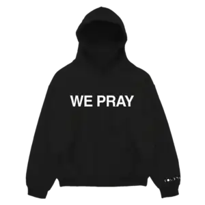 Front view of black Coldplay hoodie with bold white “We Pray” text centered on the chest.